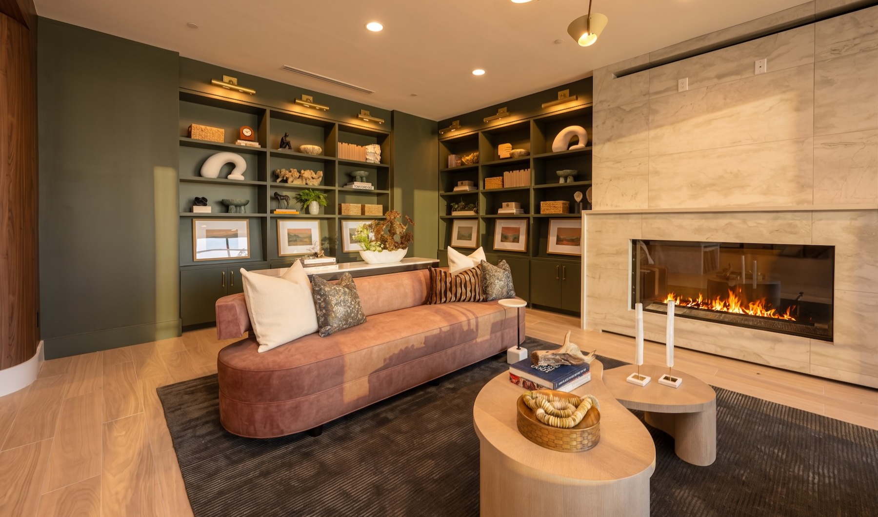 a clubroom with a couch, table and fireplace