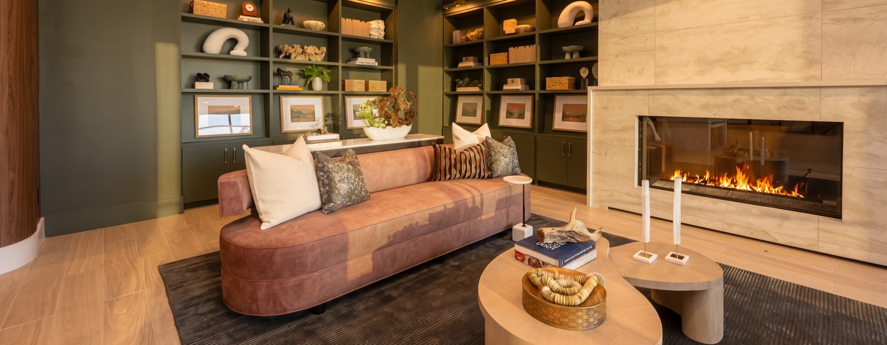 a clubroom with a couch, table and fireplace